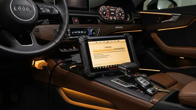 Diagnostic tablet plugged into a vehicle OBD-II port programming a new smart proximity key fob